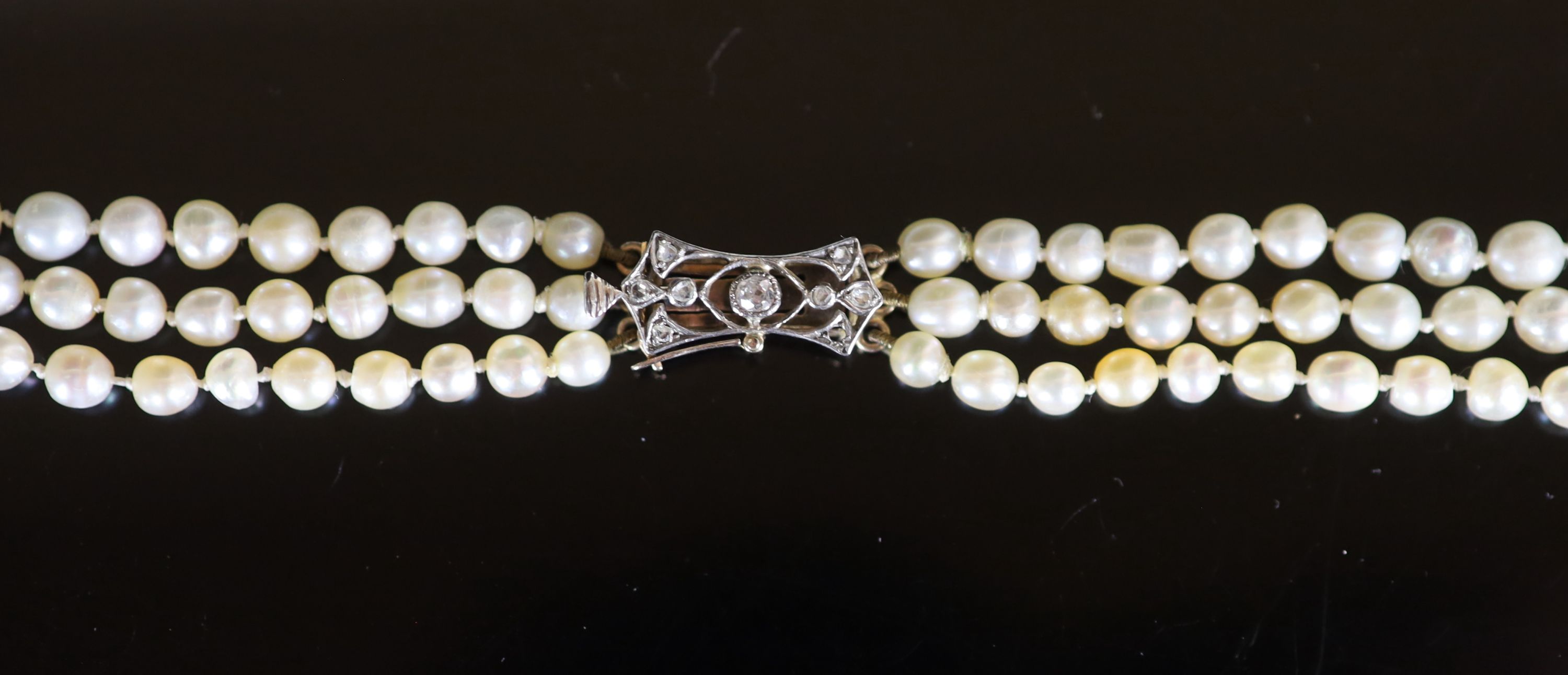 A three-row graduated pearl necklace with diamond-set openwork yellow metal clasp